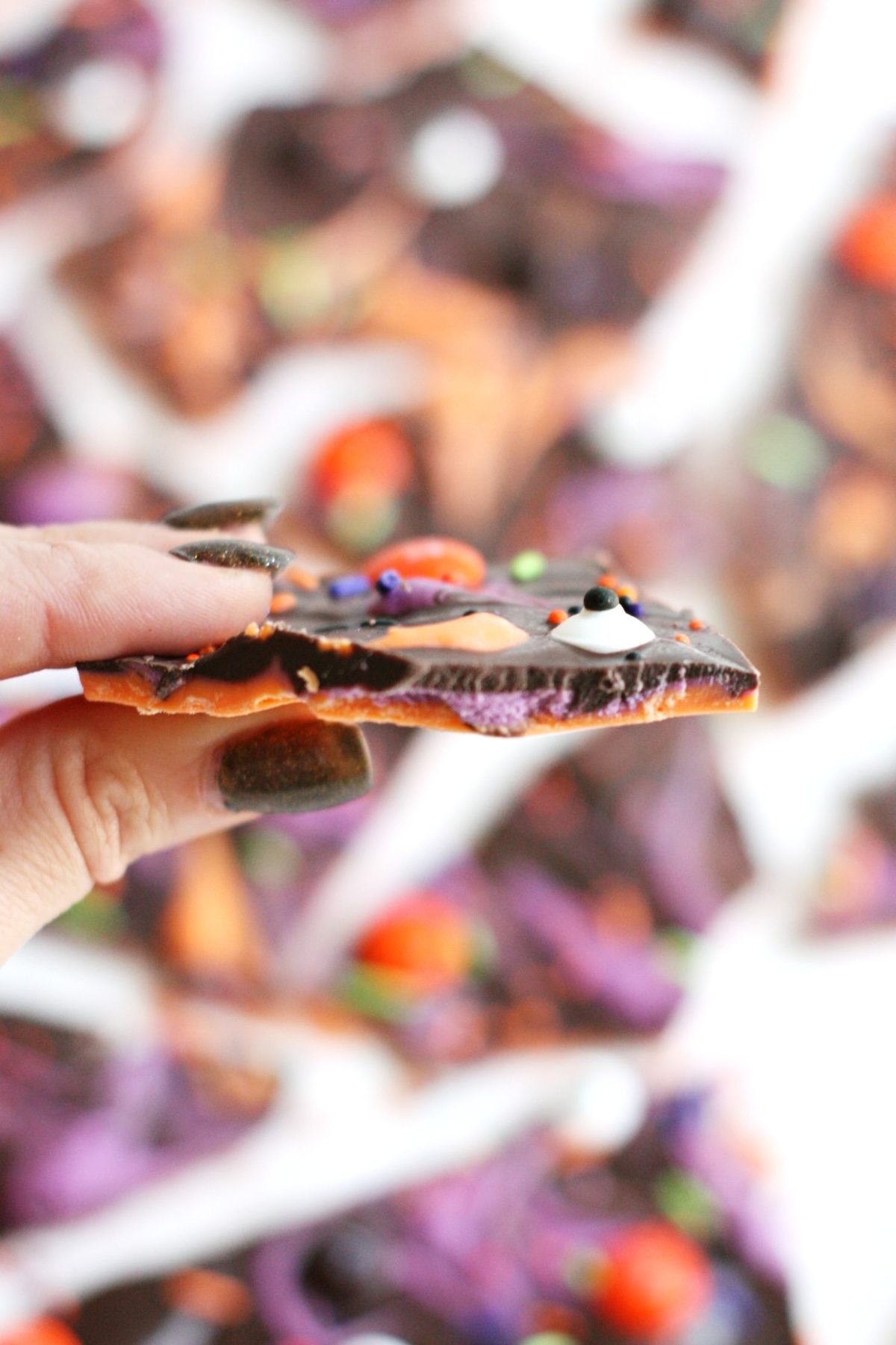 Holding a piece of spooky Halloween bark
