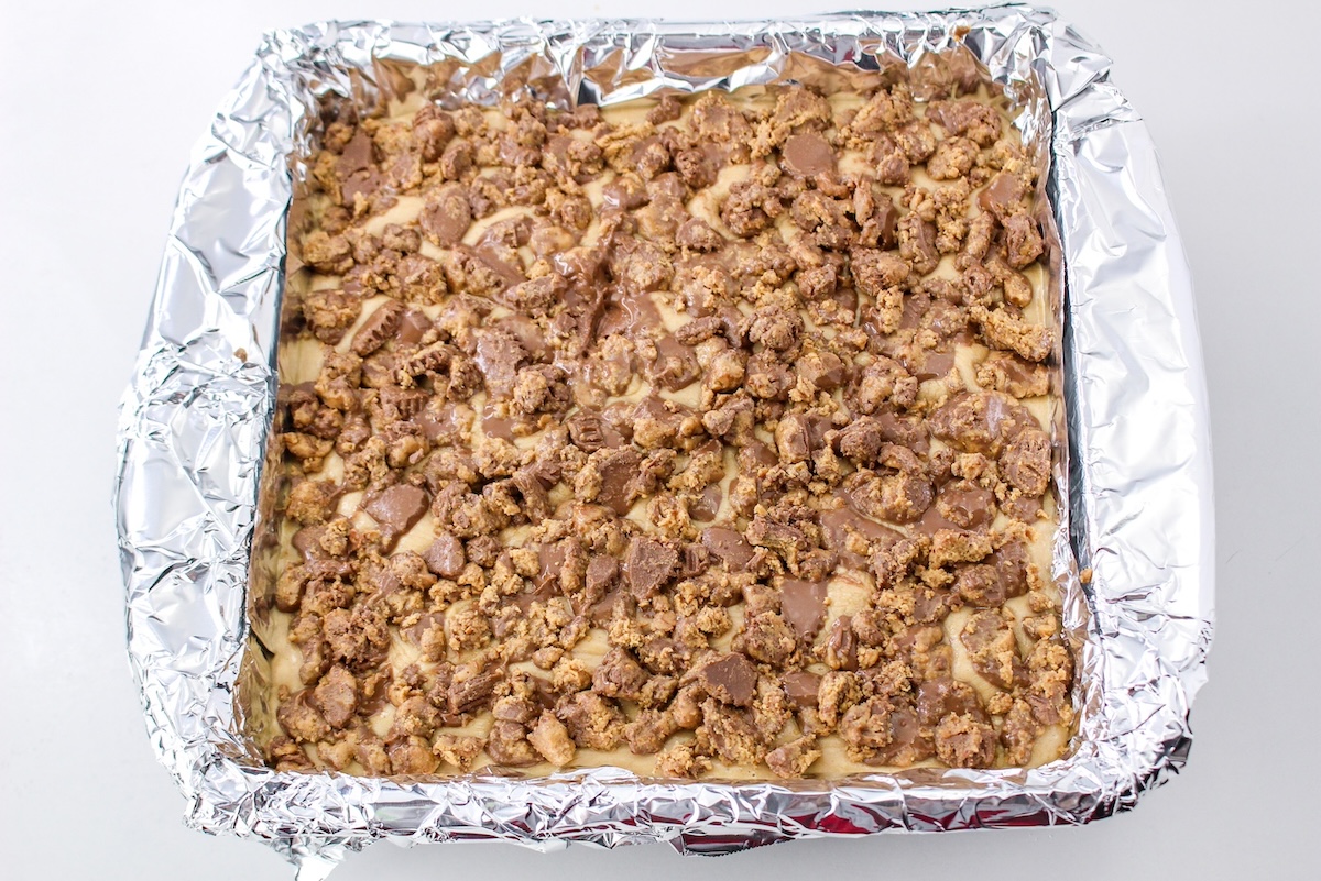 Sprinkling Reese's on top of the fudge