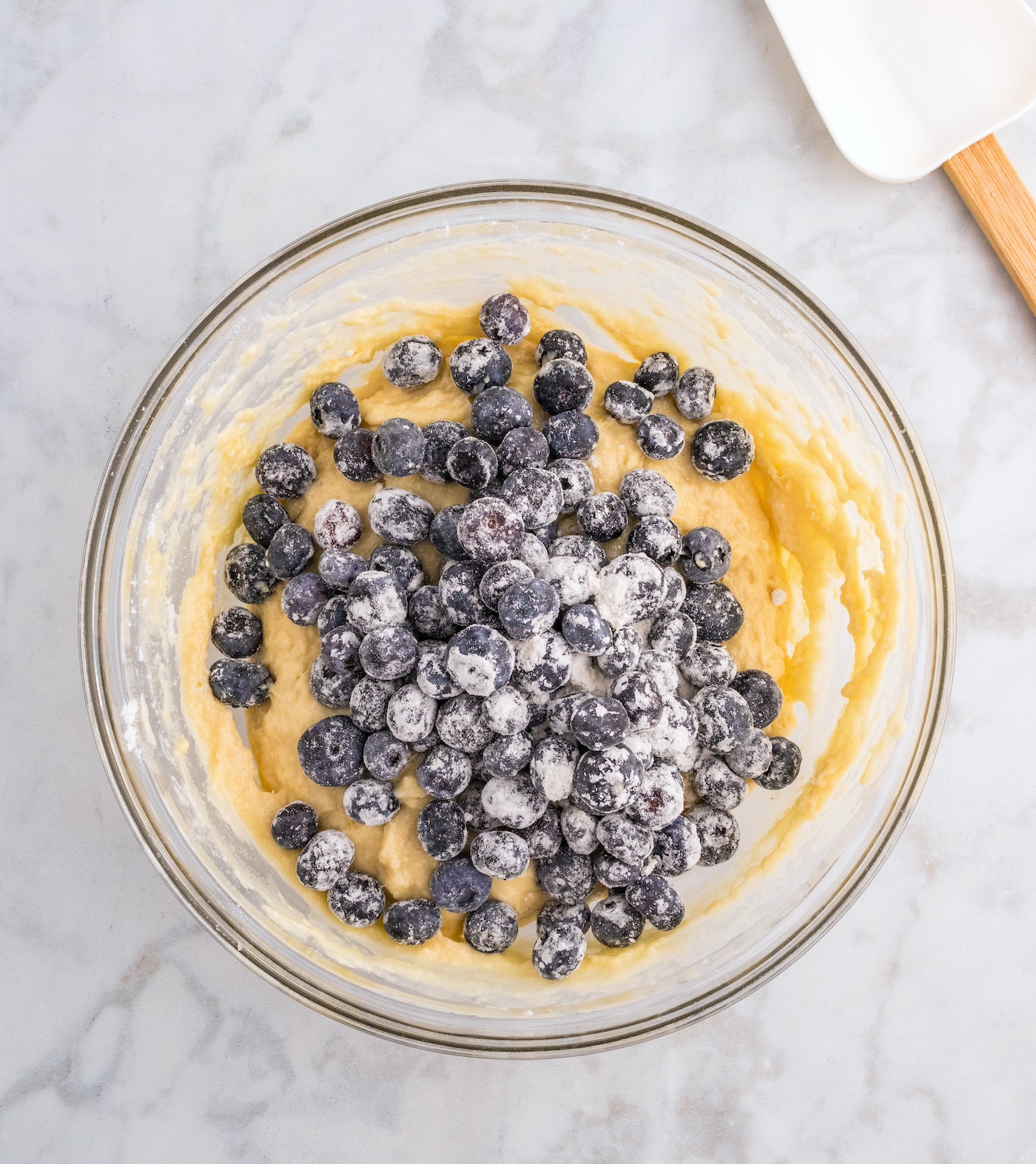 Adding blueberries to the lemon muffin batter