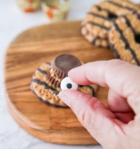 Adding candy eyeballs to the Reese's mini cup