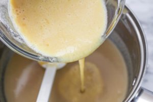 Egg mixture being added back into the ice cream mixture
