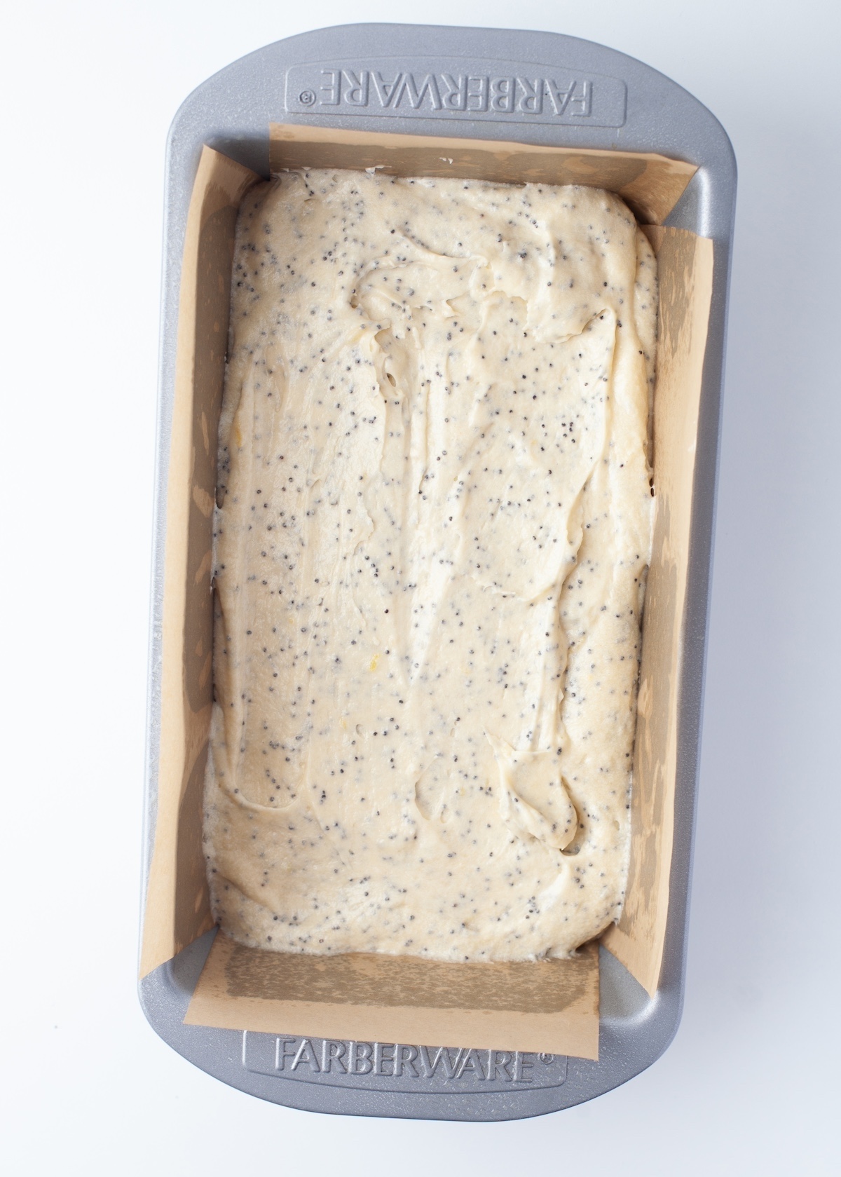 Lemon poppy seed batter added to a loaf pan