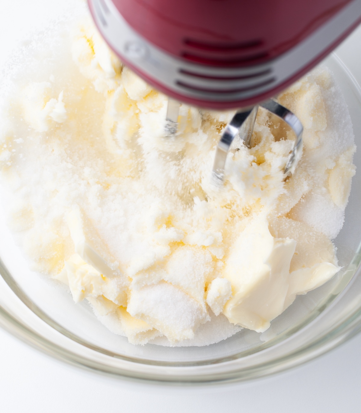 butter and sugar being creamed in a bowl with a mixer