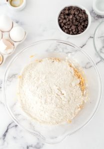 dry ingredients added to the wet ingredients in a clear glass bowl