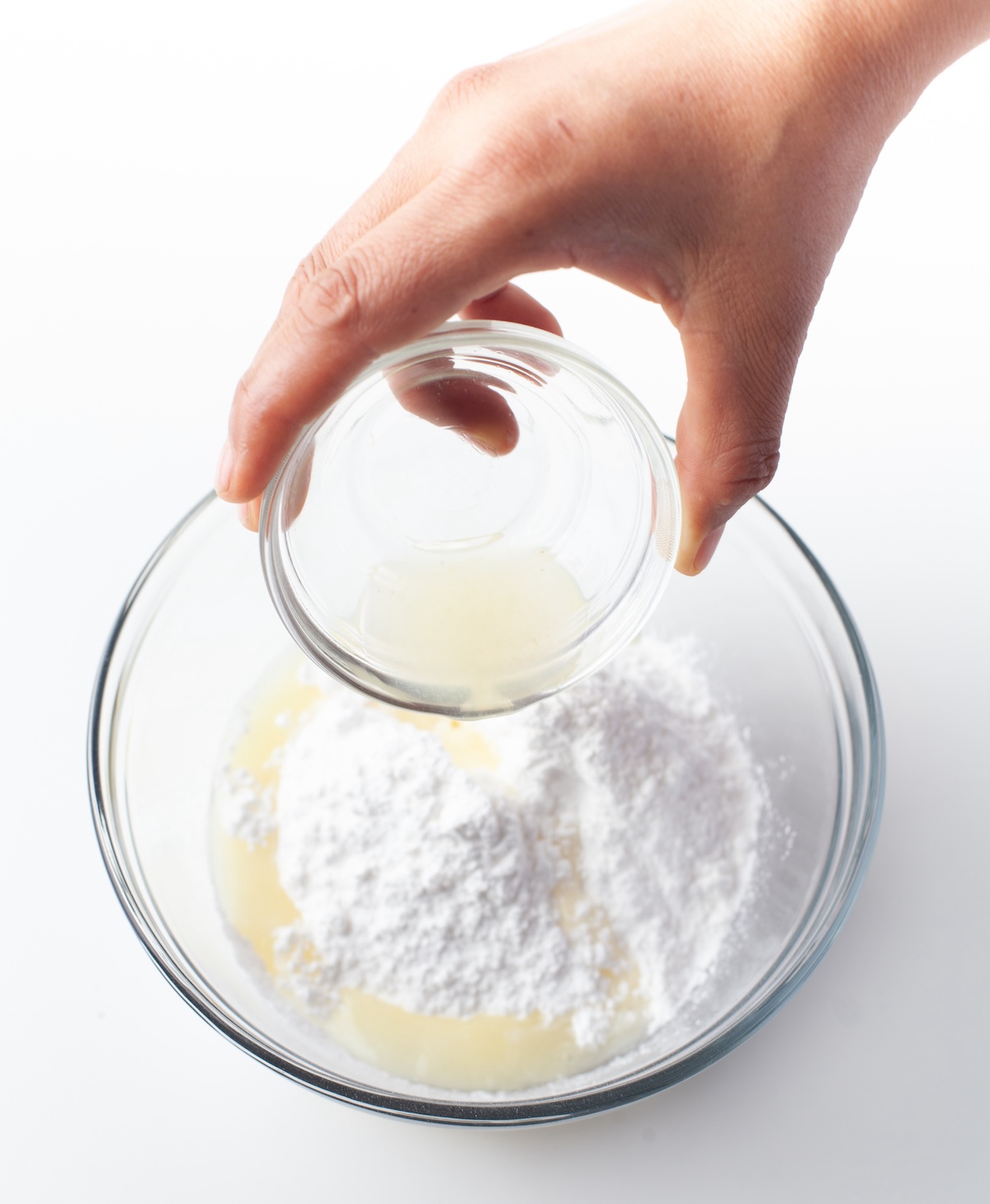 Powdered sugar and lemon being combined in a bowl