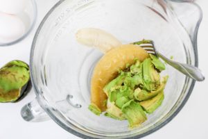Banana and avocado mashed together in a glass bowl