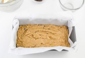 bread batter added to a pan lined with parchment