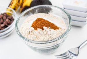 whole wheat flour, baking soda, baking powder, salt, and cinnamon in a glass bowl