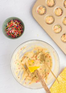 Adding funfetti batter to a muffin tin