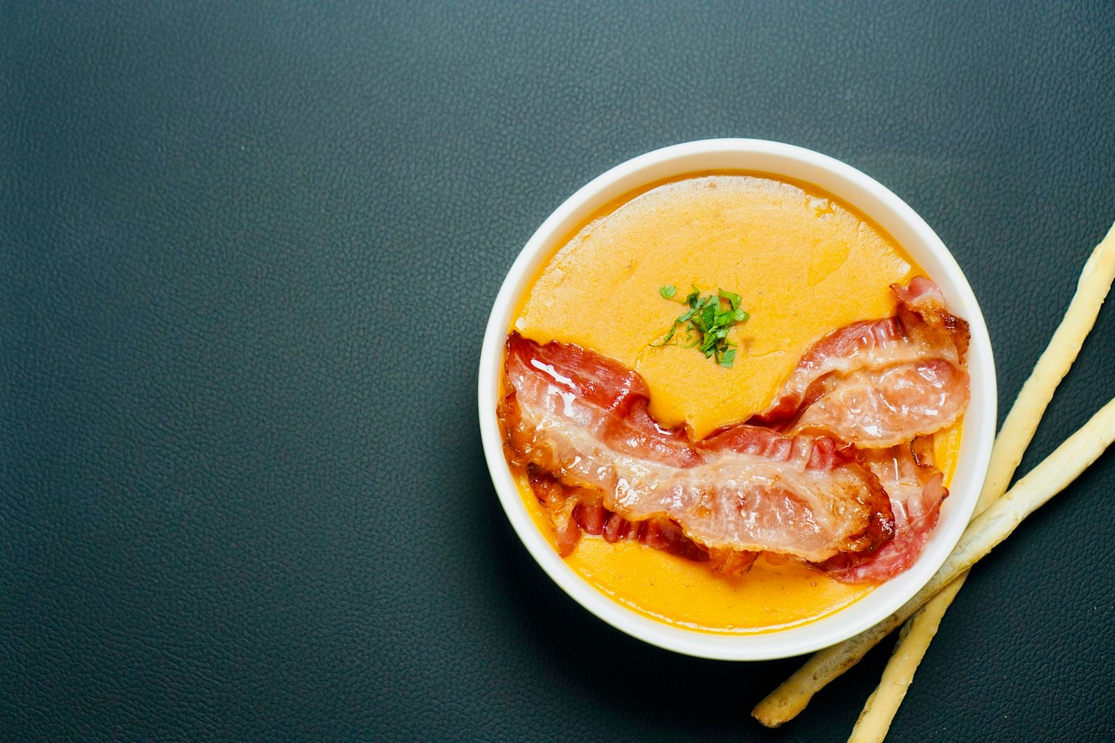 Bacon and melted cheddar in a white bowl