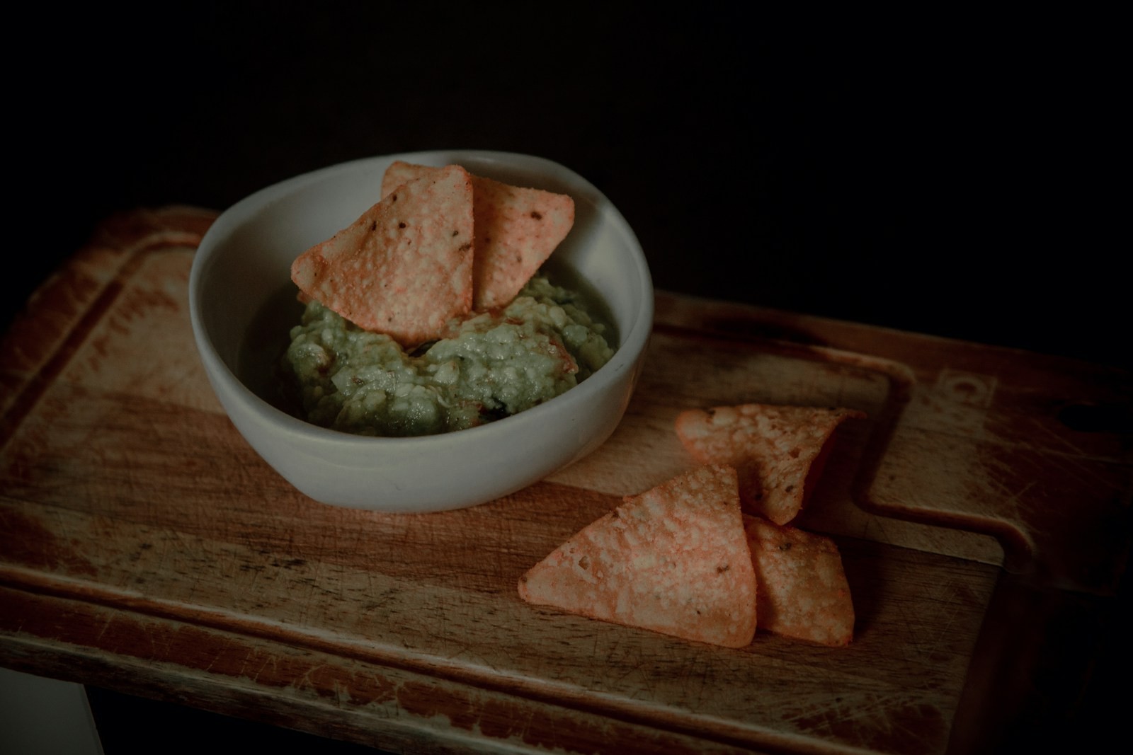 Spinach and artichoke spread in a white bowl with pita chips