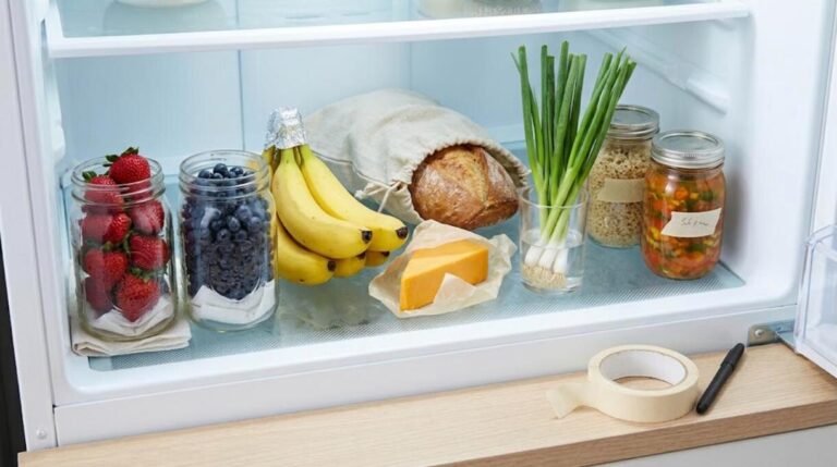 Tidy refrigerator shelf with labeled jars, berries, cheese and bread