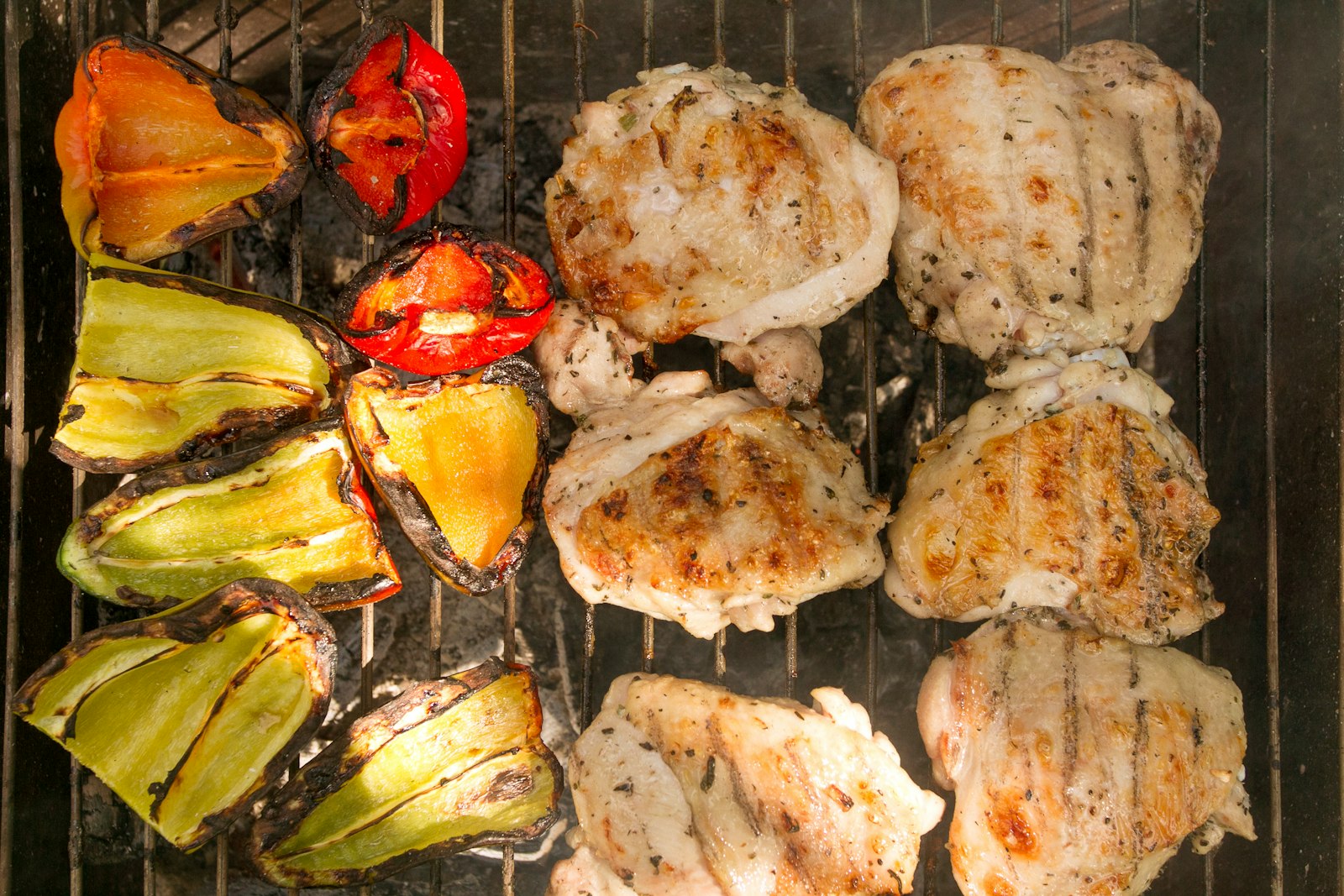 Chicken and vegetables cooking on a grill