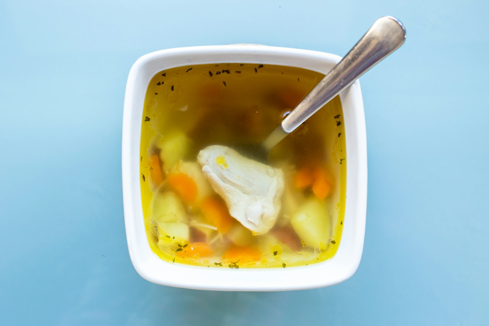 Bowl of vegetable soup with lemon slices