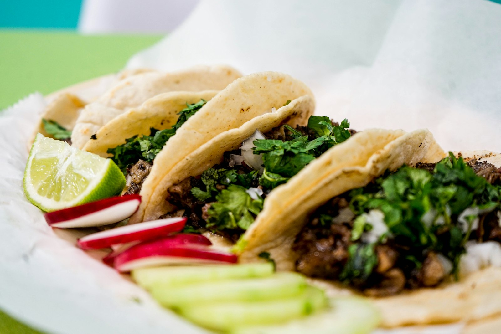 Pork carnitas tacos with cilantro, onion and lime wedges