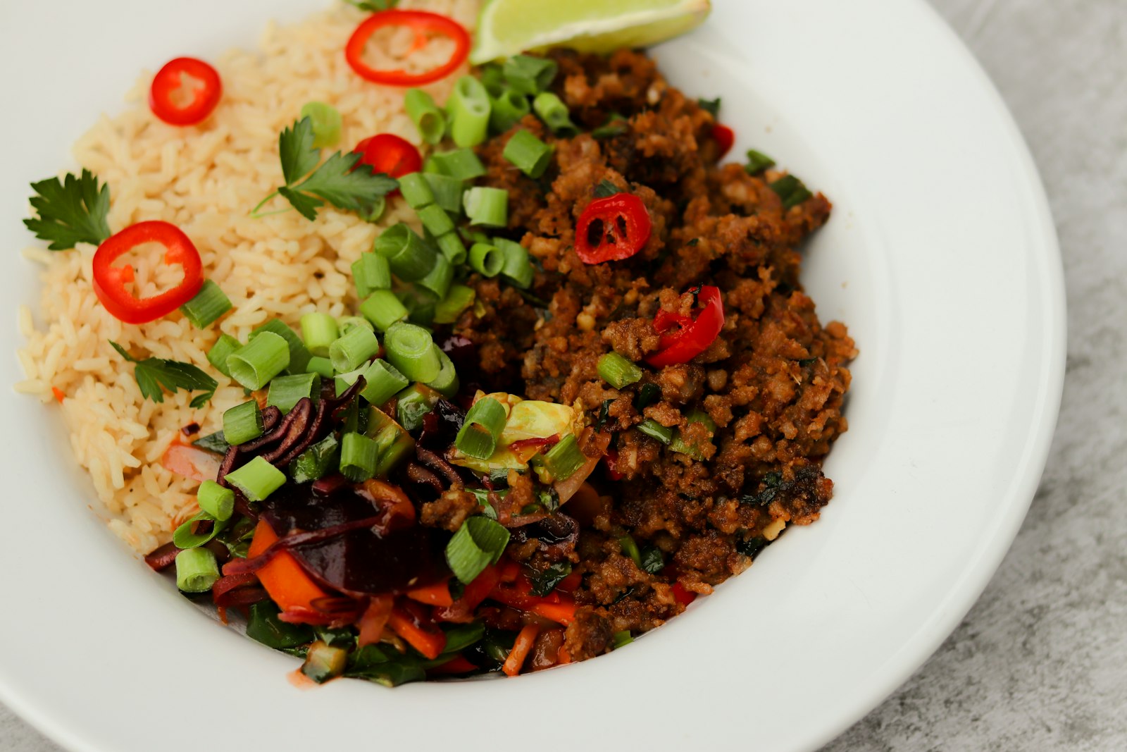 Slow cooker dinners: beef chili topped with fresh tomato and avocado served with rice