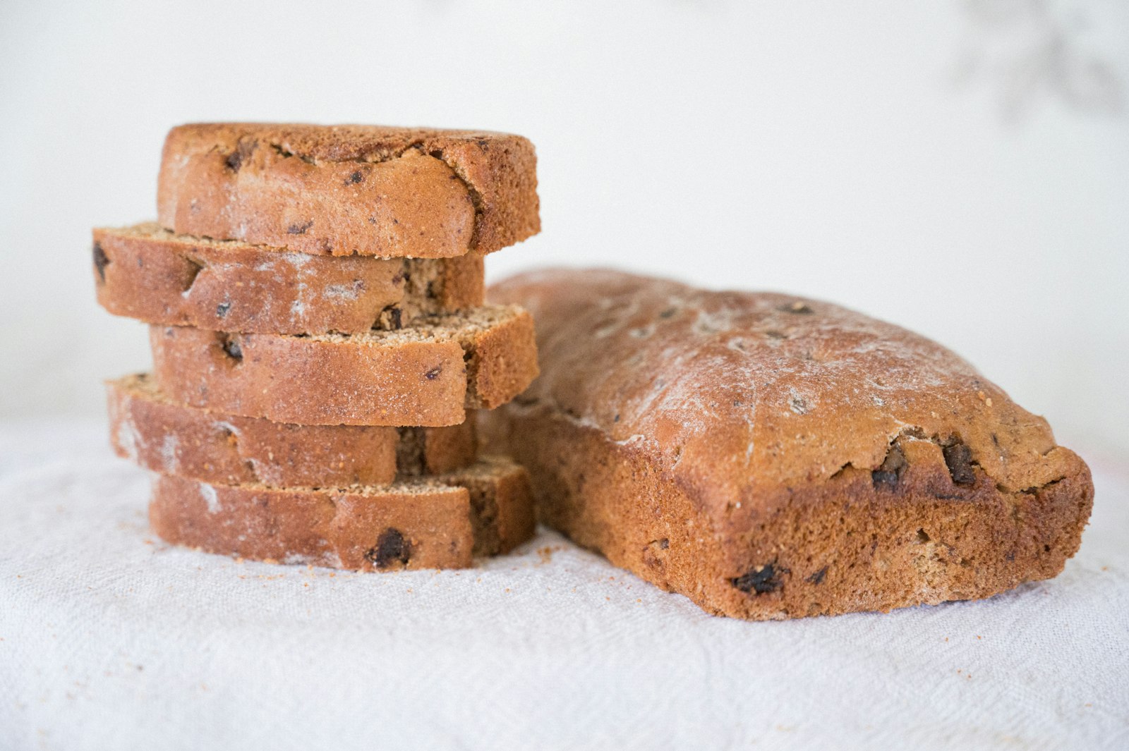 Sliced cranberry orange bread loaf on a white table