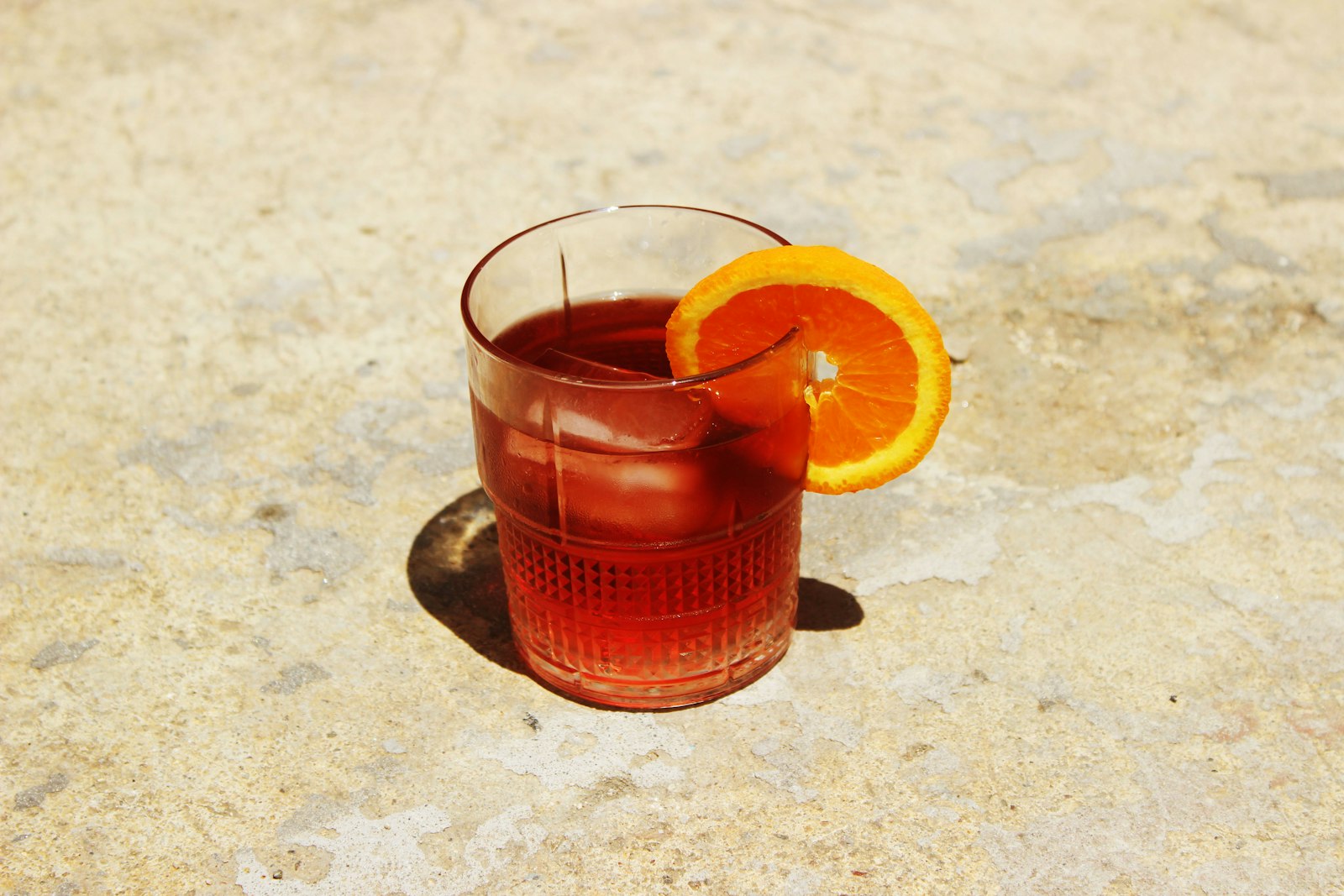 Cranberry orange spritz in a glass with an orange slice