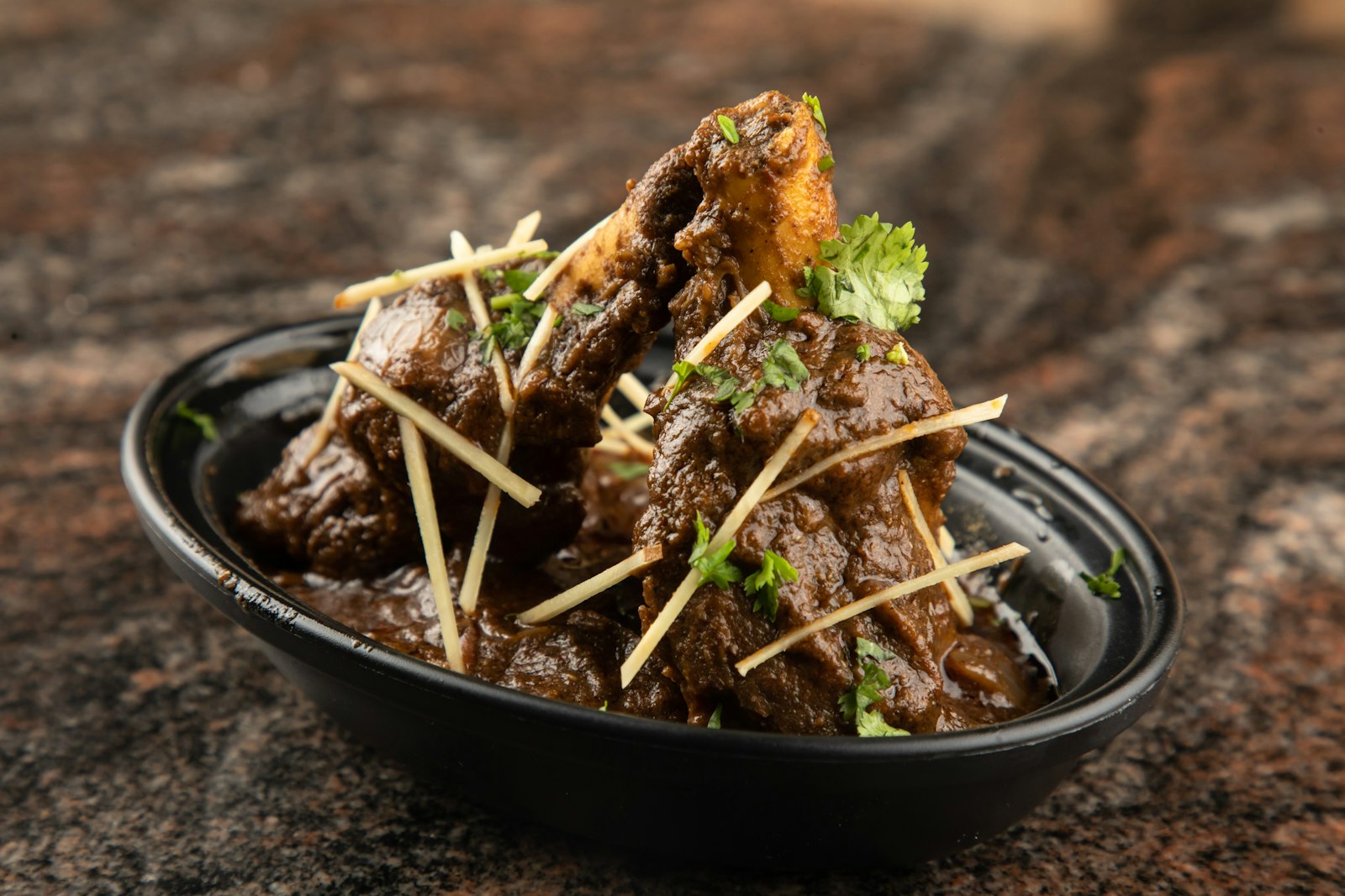 Lamb dinners: slow braised lamb shanks in a dark bowl