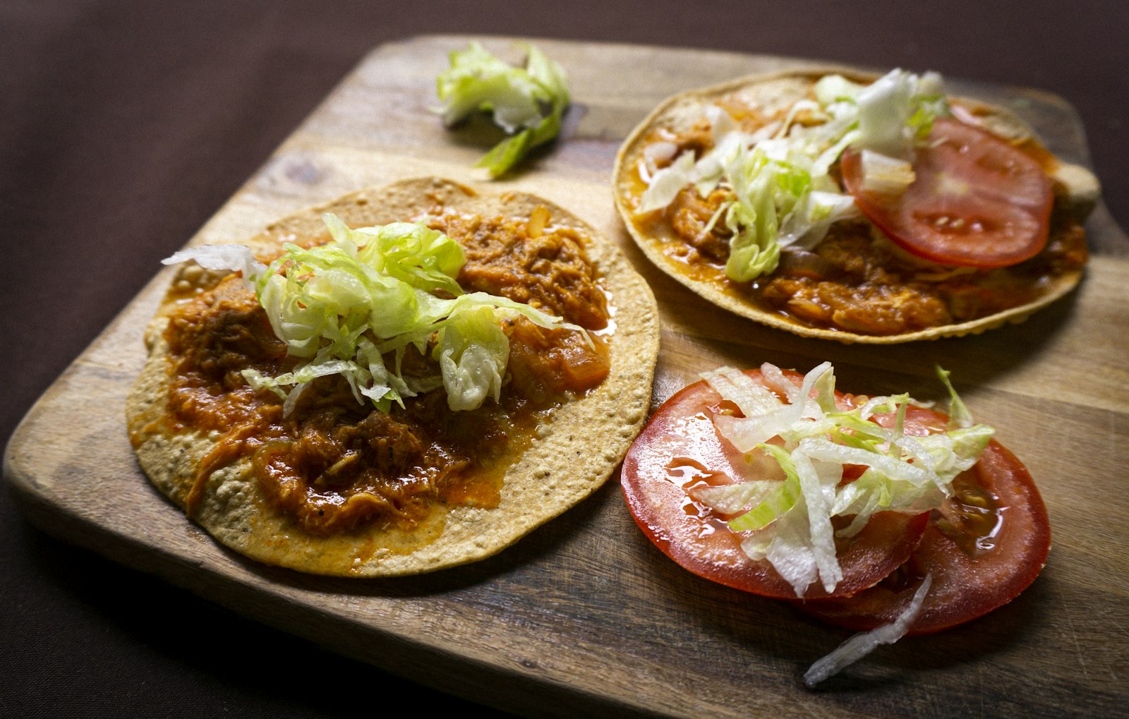 Crispy tostadas topped with shredded chicken, lettuce and tomato