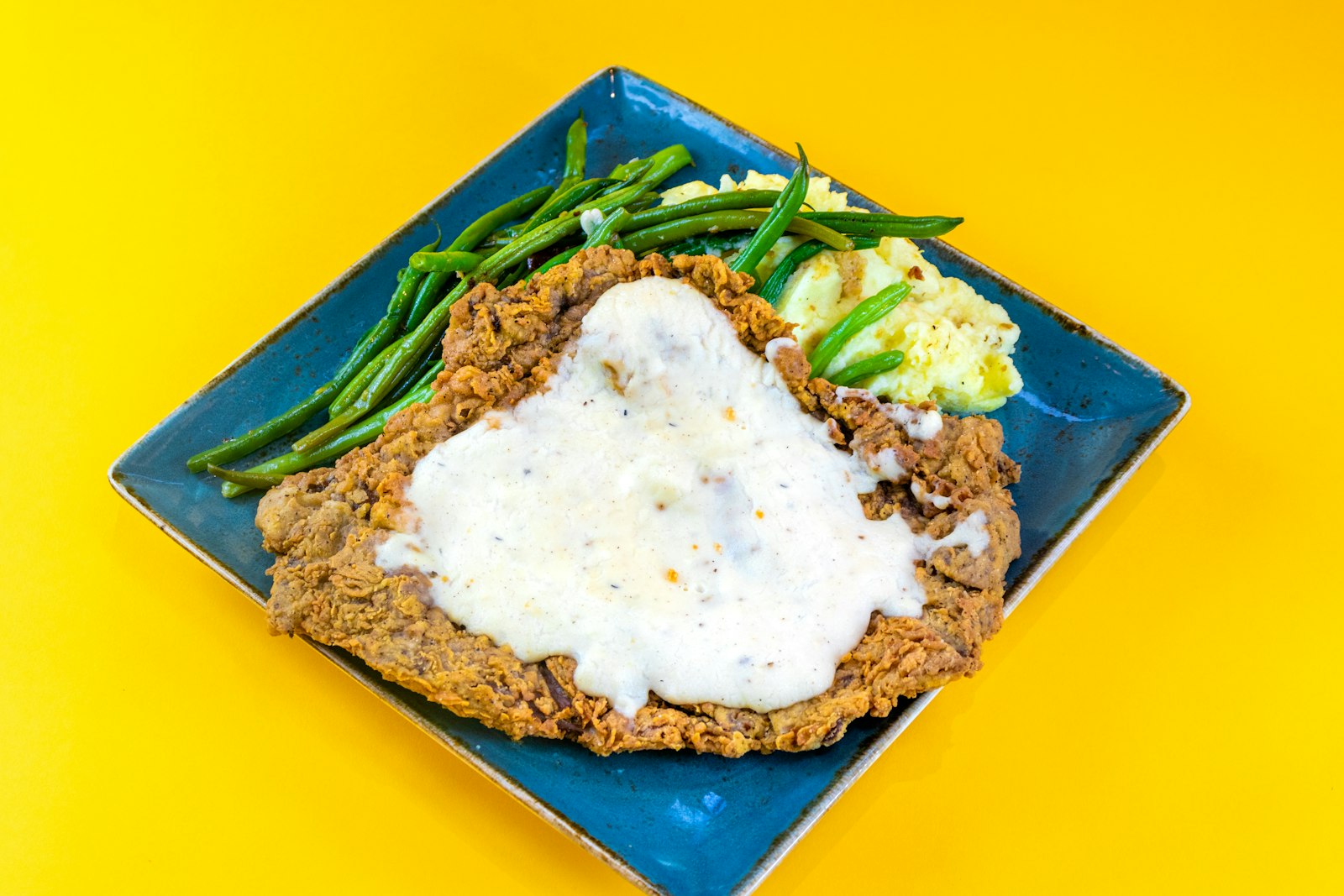 Country fried cutlet with white gravy and green beans