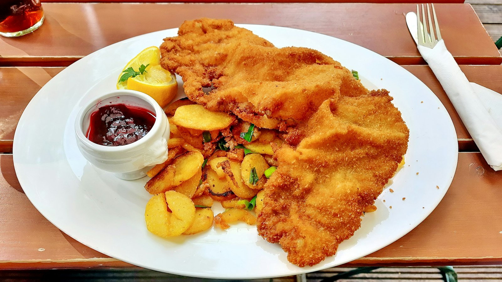Golden schnitzel with berry sauce and fries
