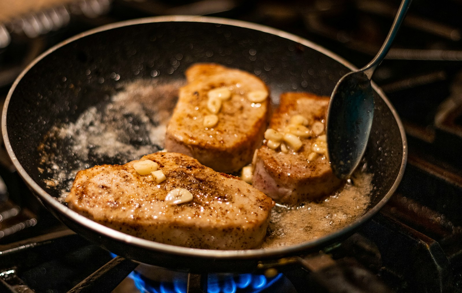 Pork chop dinners butter basted chops in a skillet