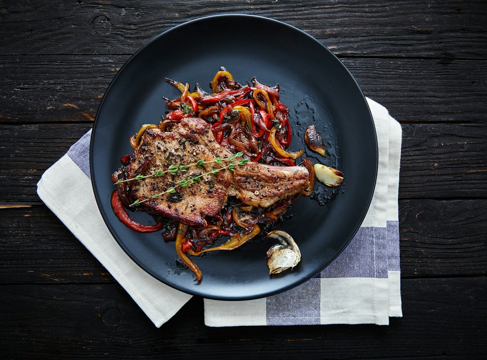 Seared bone in cutlet with apple slaw on a dark plate