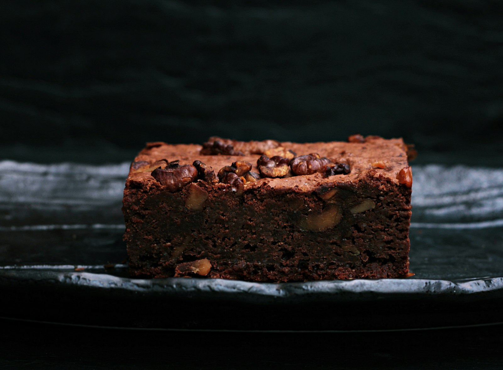 Fudgy chocolate brownie on a dark board
