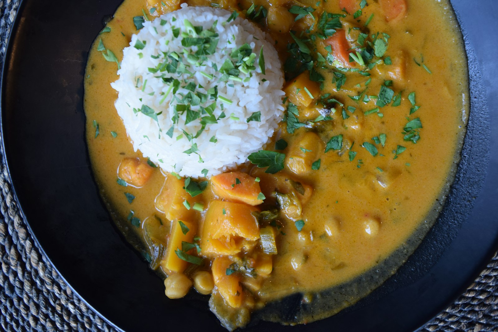 Golden coconut curry with rice in a dark bowl