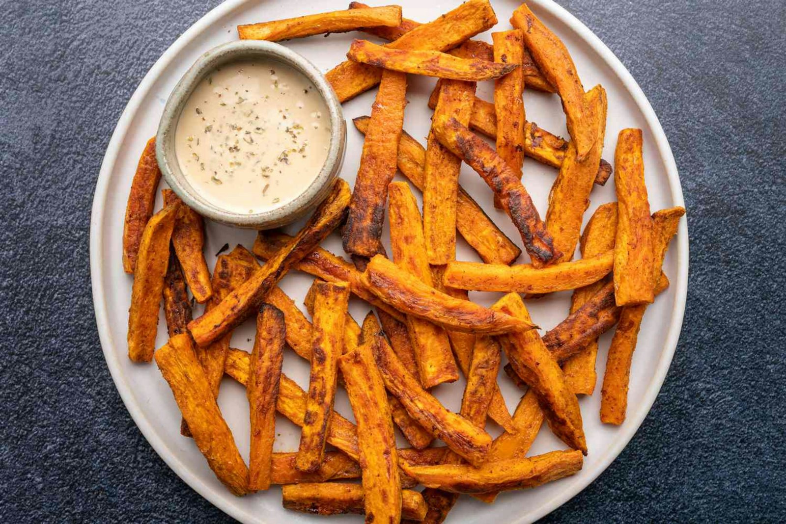 Crispy baked orange fries with a creamy dipping sauce