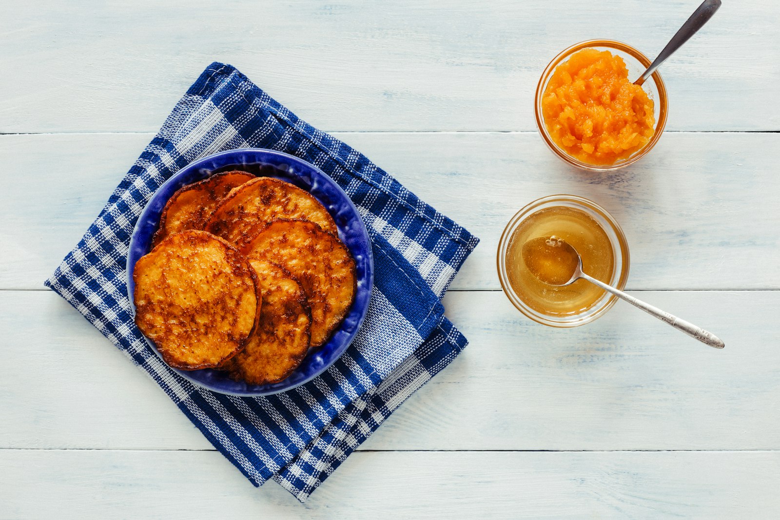 Sweet potato pancakes on a blue plate with honey