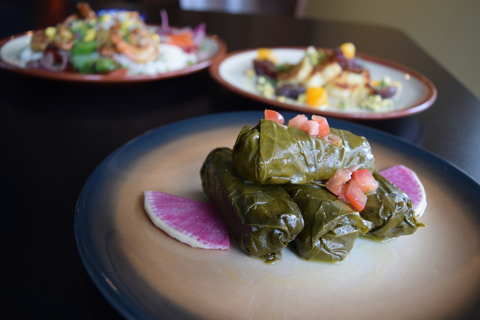 Grape leaf rolls with pomegranate seeds and radish