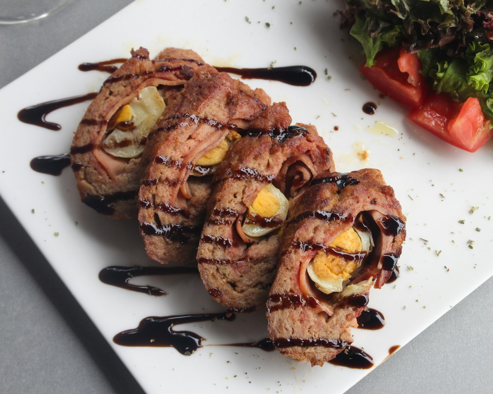 Sliced pork roulades with egg and vegetable filling