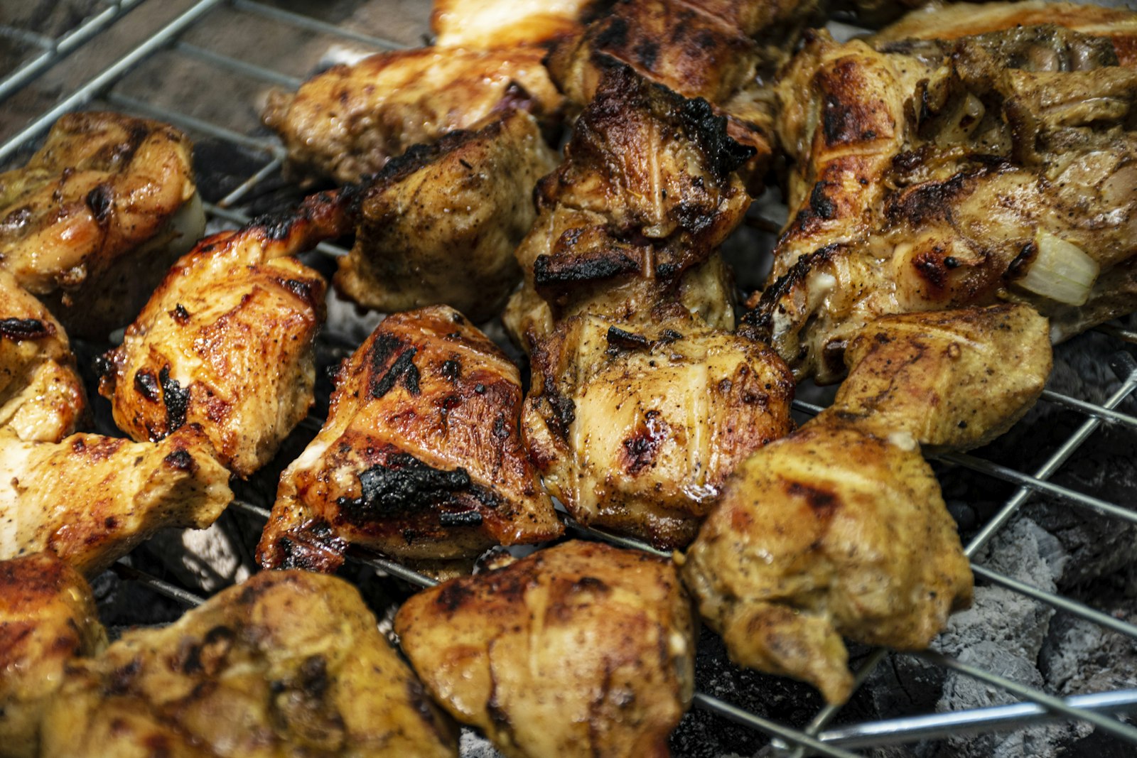 Sticky grilled BBQ chicken pieces on the grill