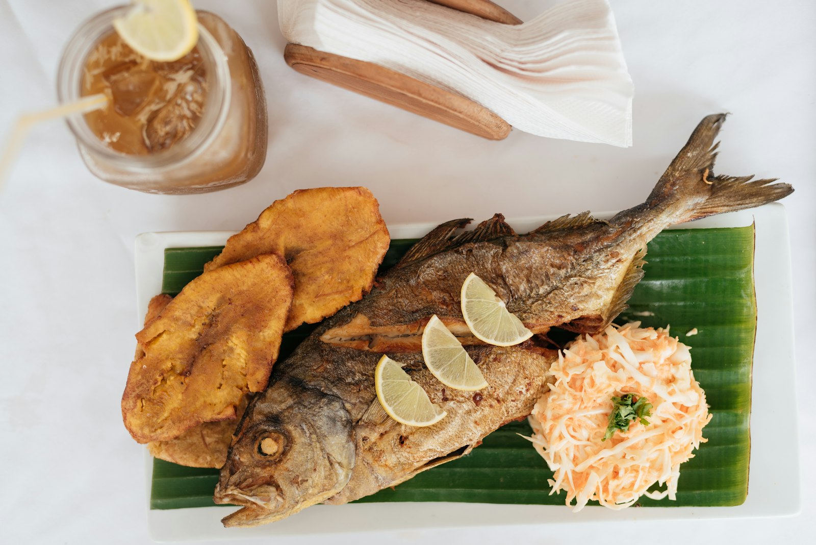 Whole fried fish with plantains and lime