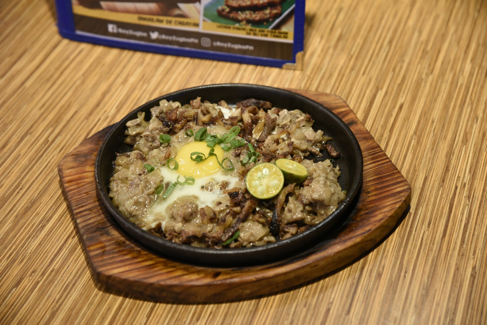 Filipino pork sisig on a sizzling plate with an egg
