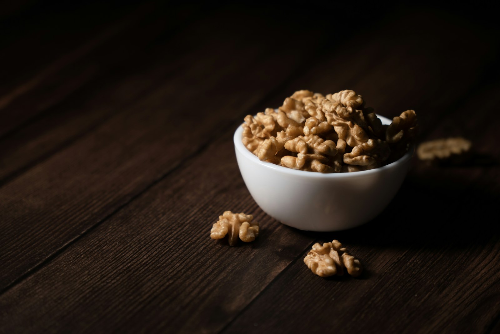Bowl of walnuts on a dark wooden table