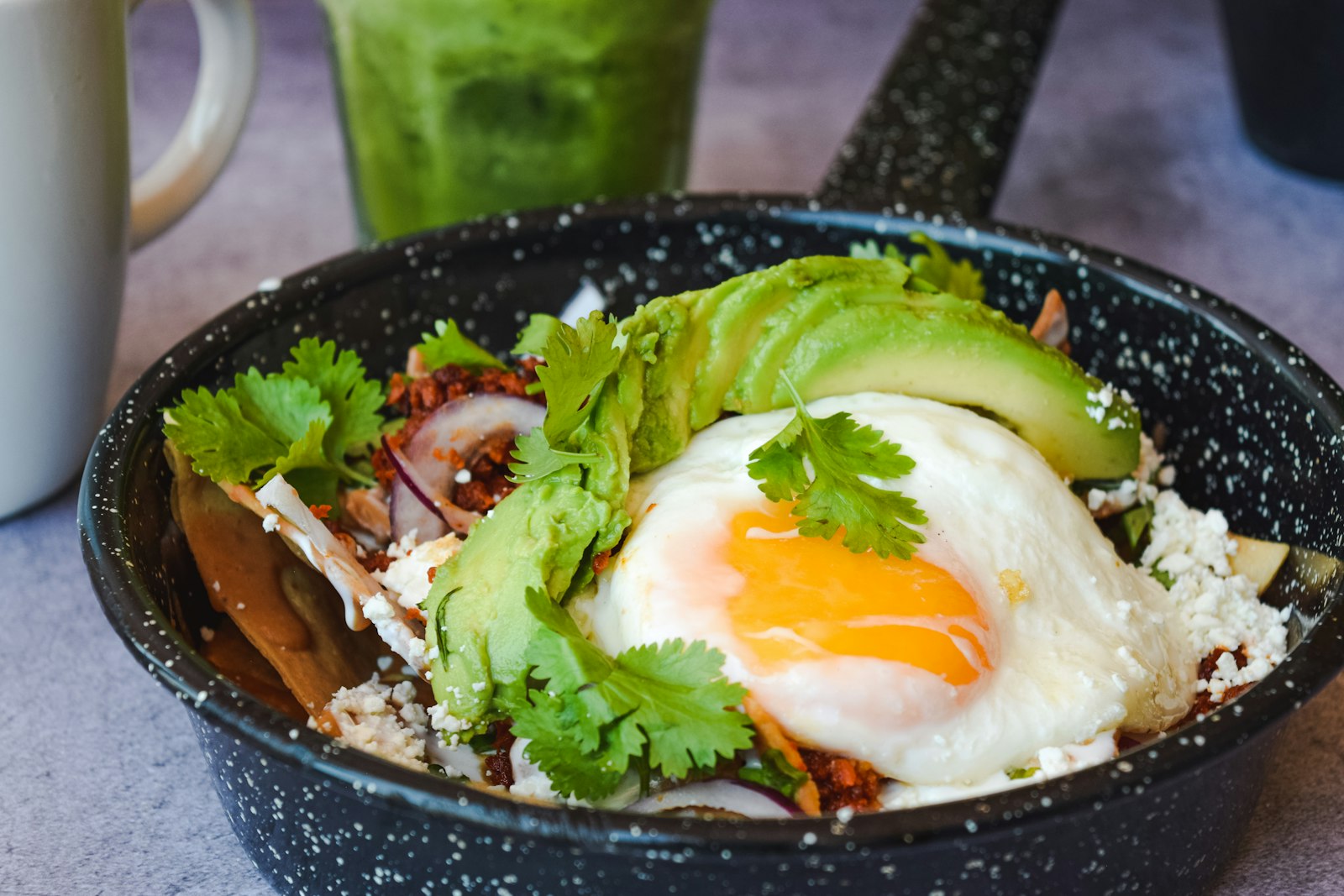 Fried egg with avocado slices and cilantro over rice