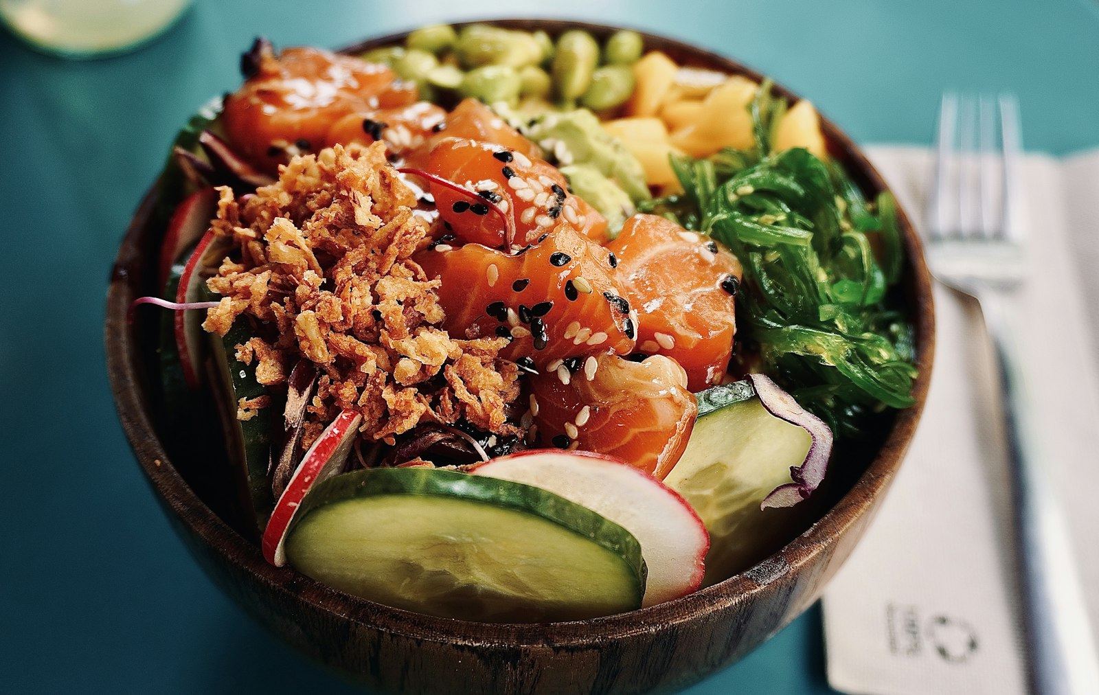 Poke style salmon with cucumber, radish and crispy onions, one of the freshest buddha bowls