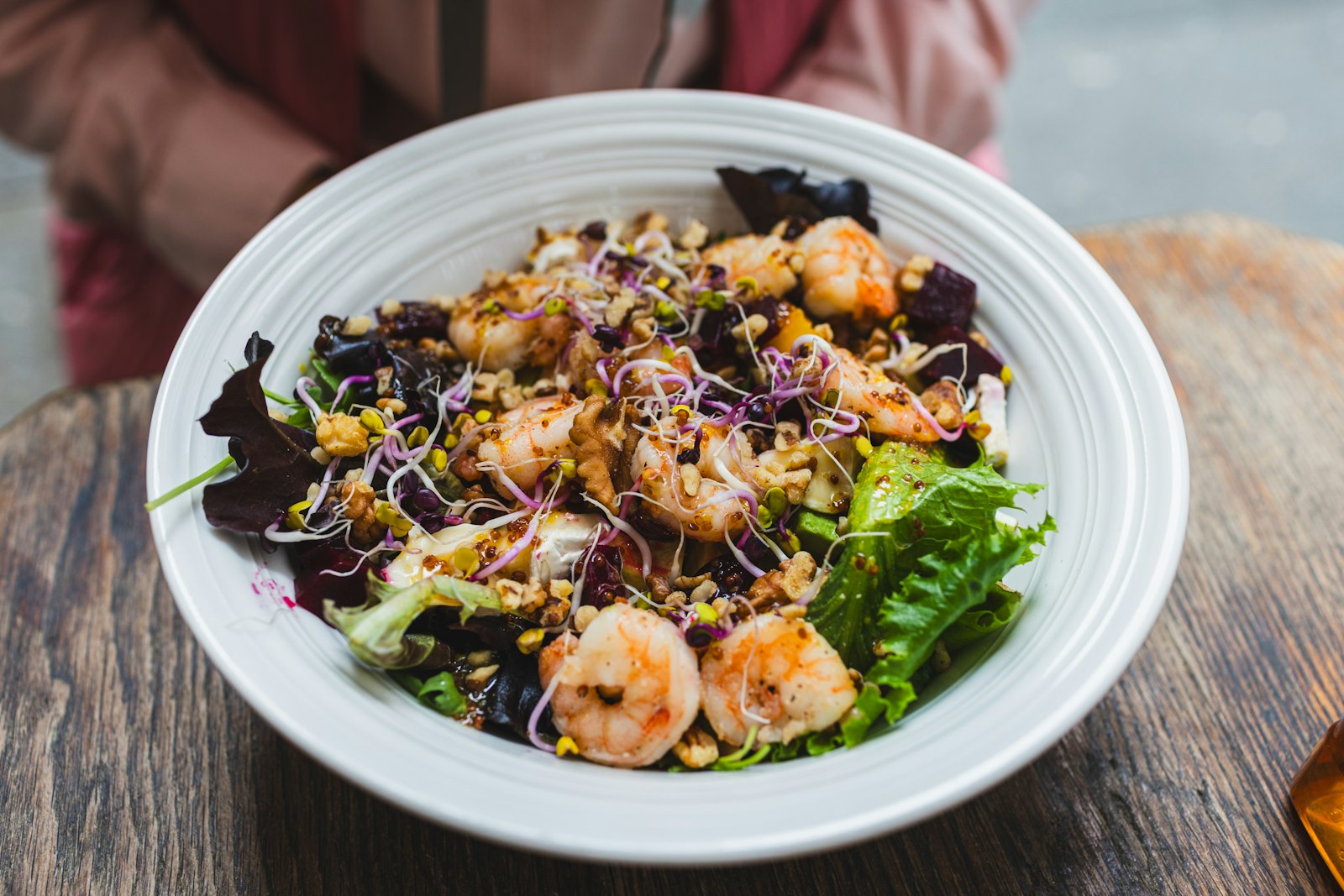 Shrimp with grains, sprouts and greens on a white plate
