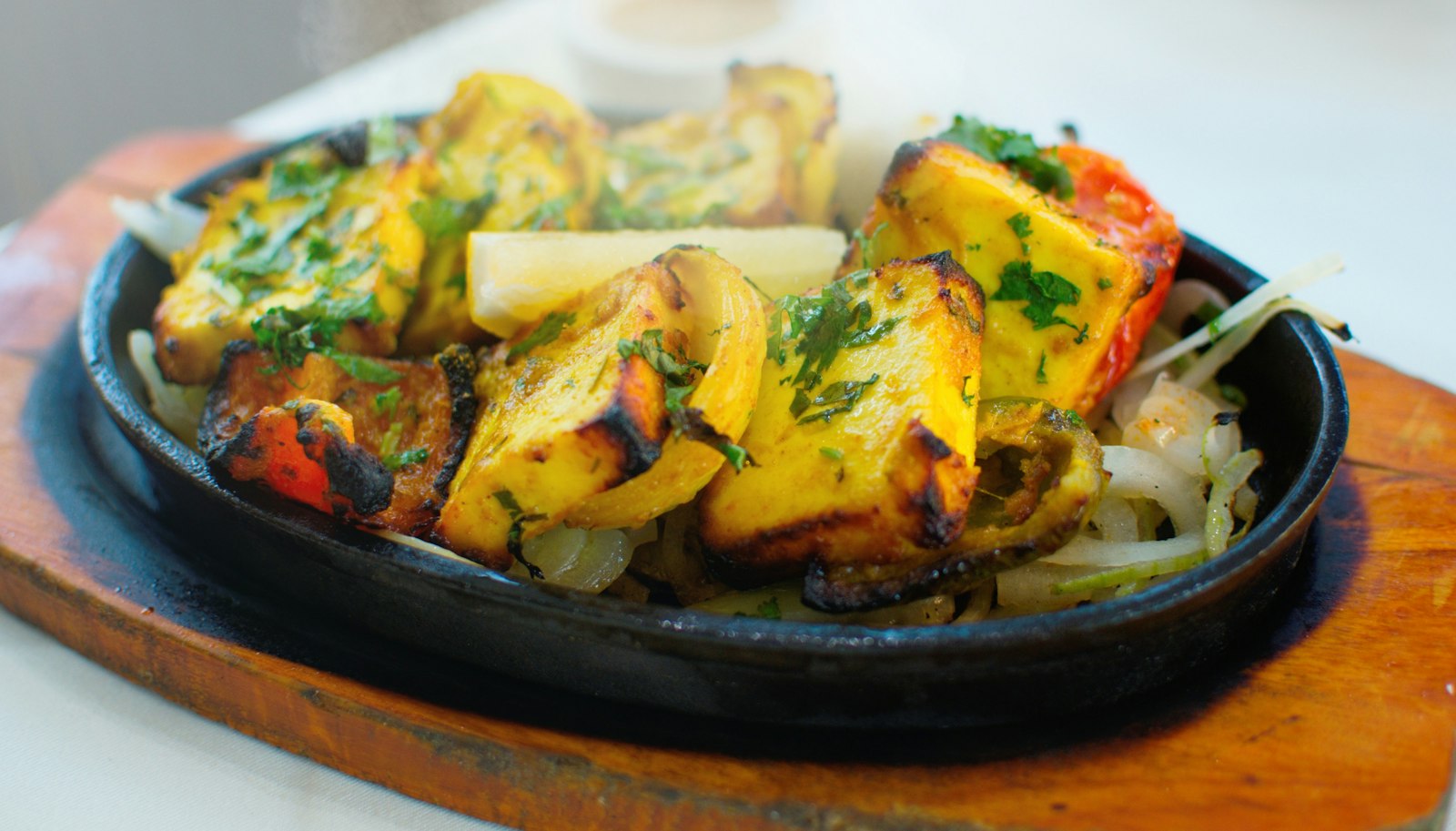 Grilled paneer tikka with peppers on a skillet