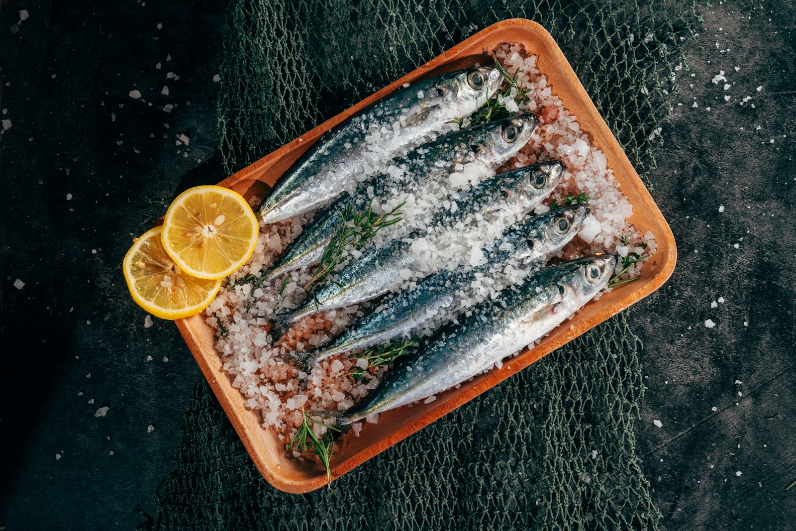 Grilled sardines with lemon slices on a tray
