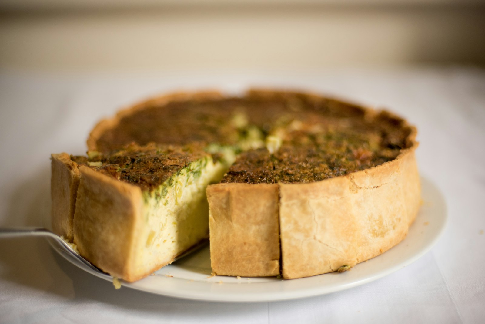 Slice of spinach quiche with a golden crust