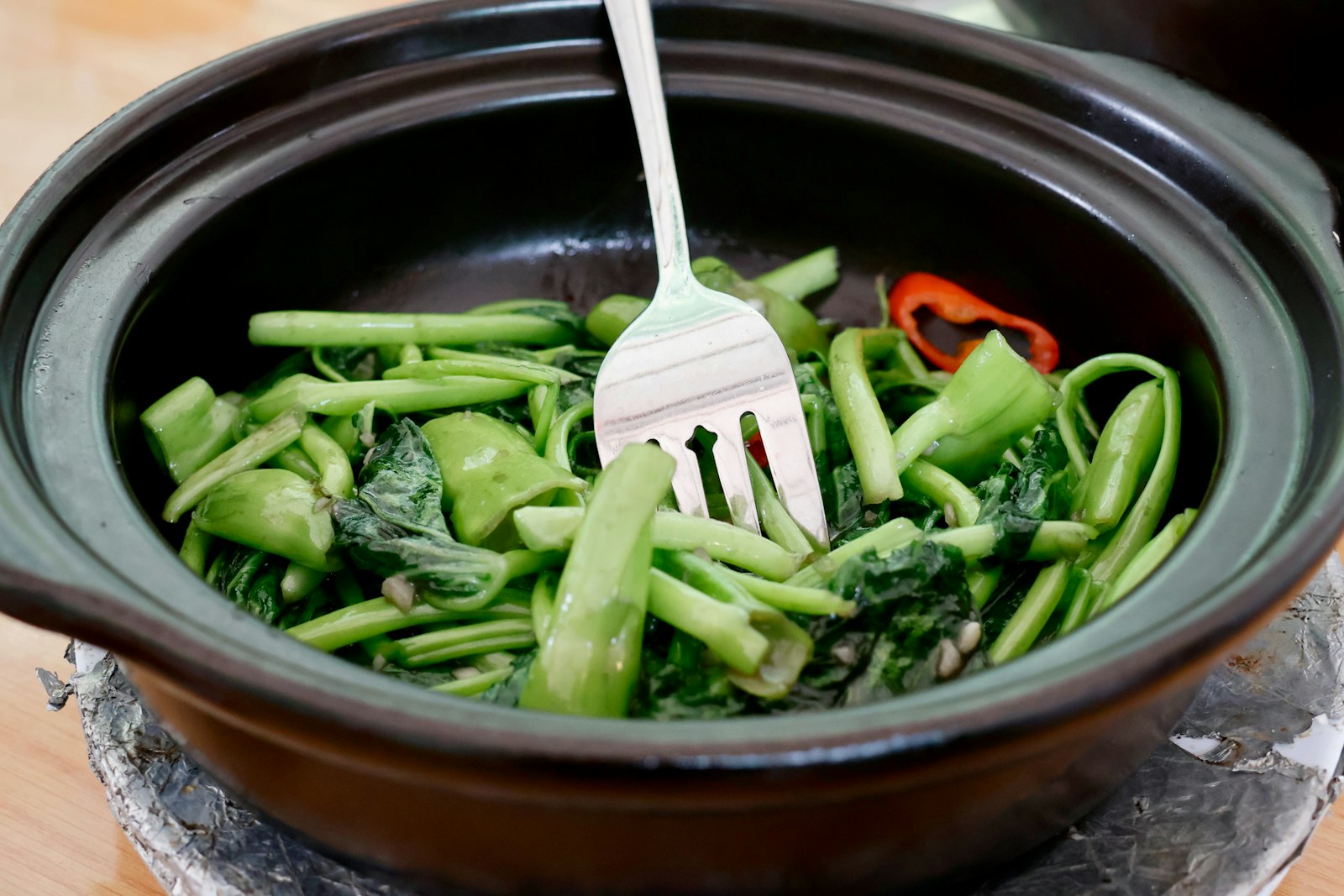 Garlic stir fried leafy greens in a clay pot