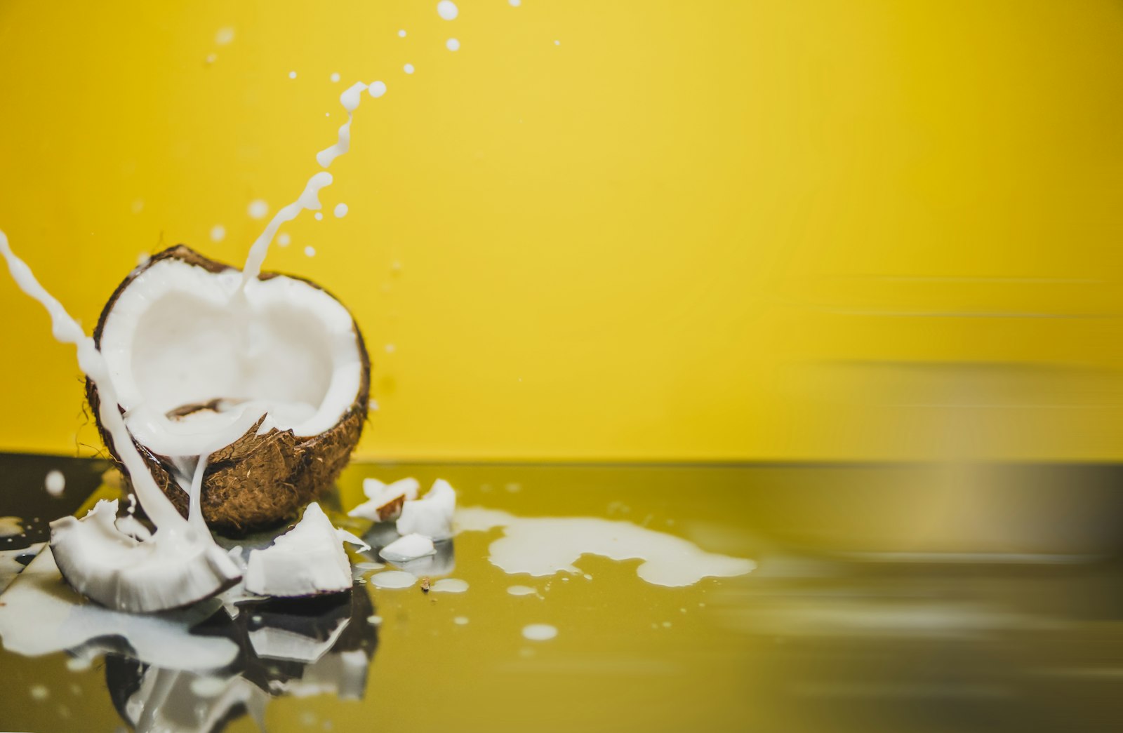 Fresh coconut splashing on a yellow background