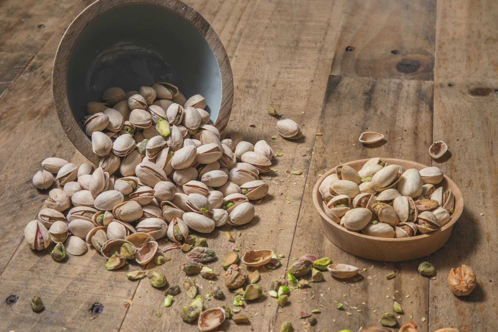 Pistachios in a wooden bowl on a rustic table