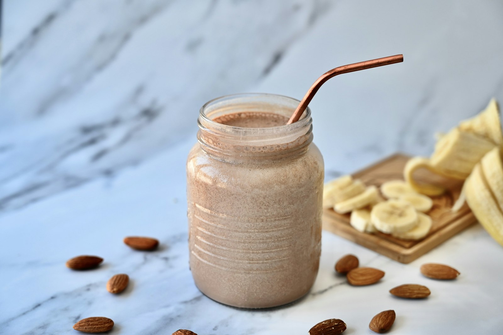 Banana almond breakfast shake in a jar with a straw