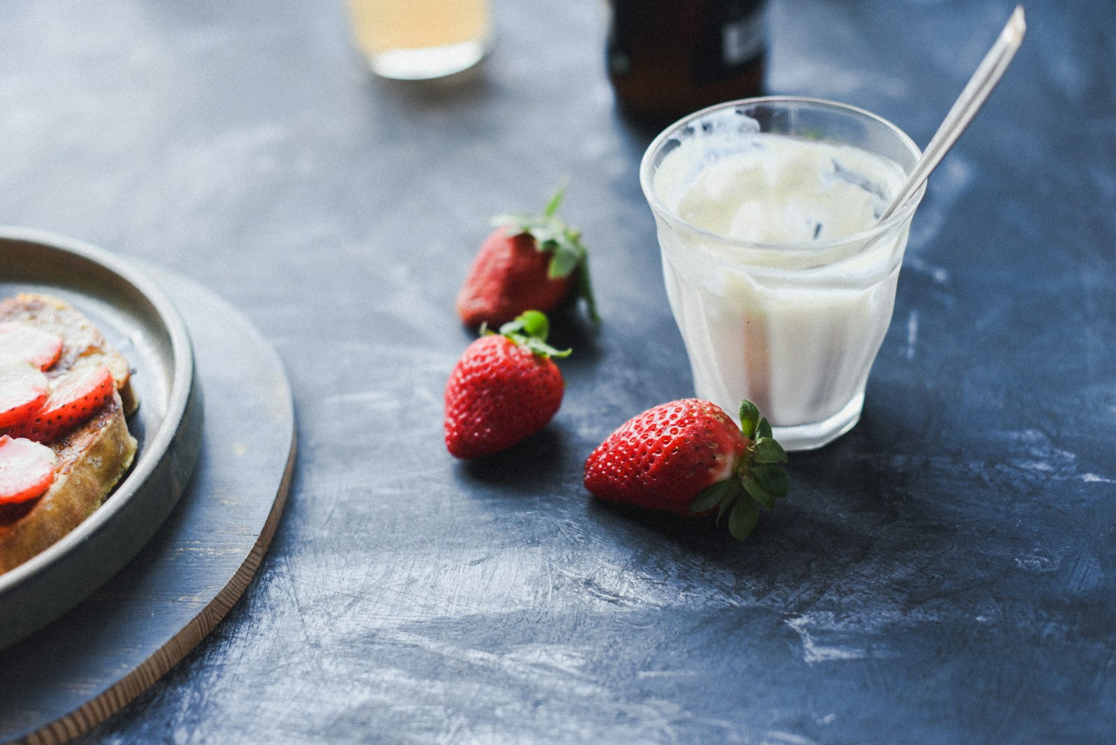 Strawberry milk in a glass with fresh strawberries