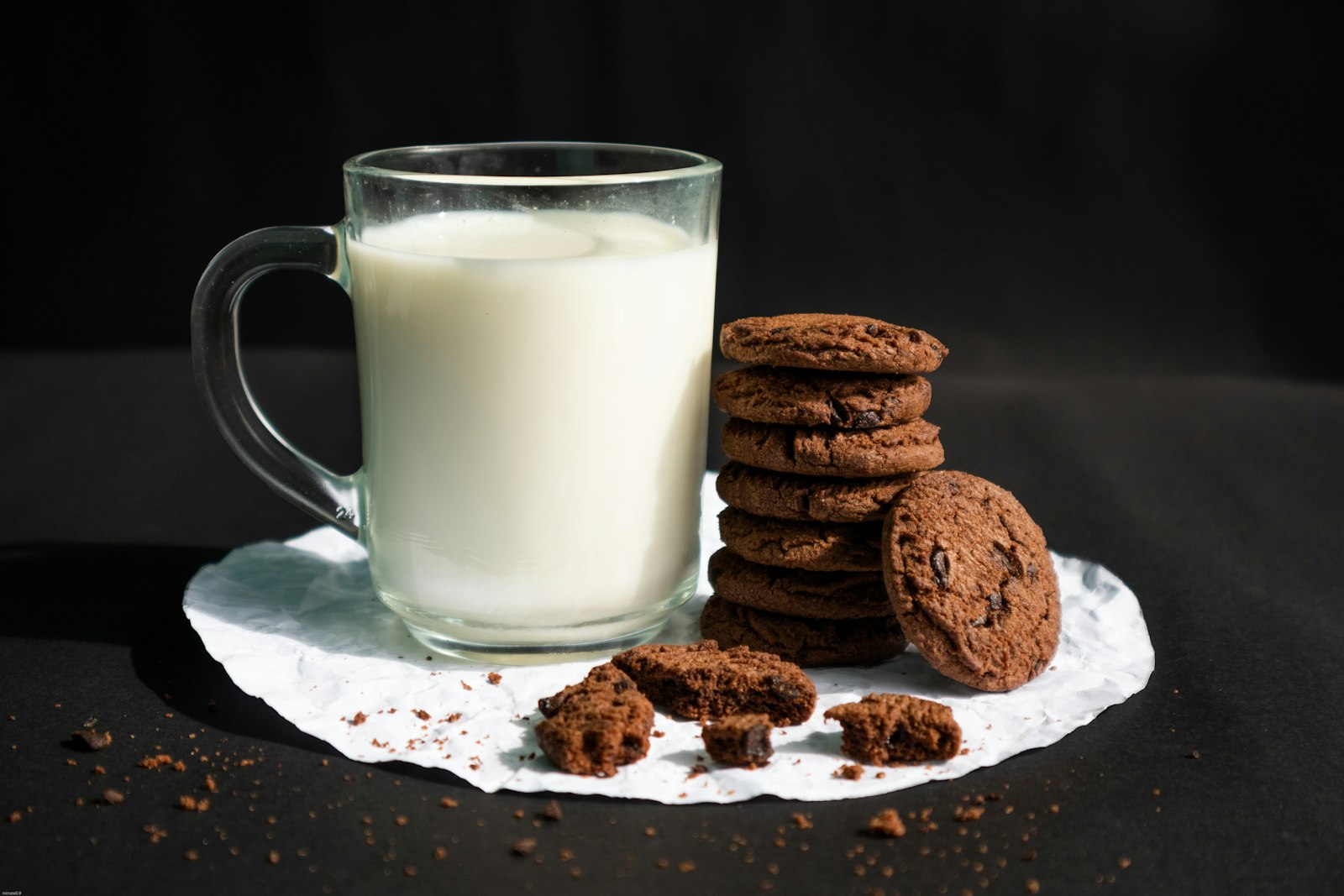 Glass of vanilla oat drink with chocolate cookies